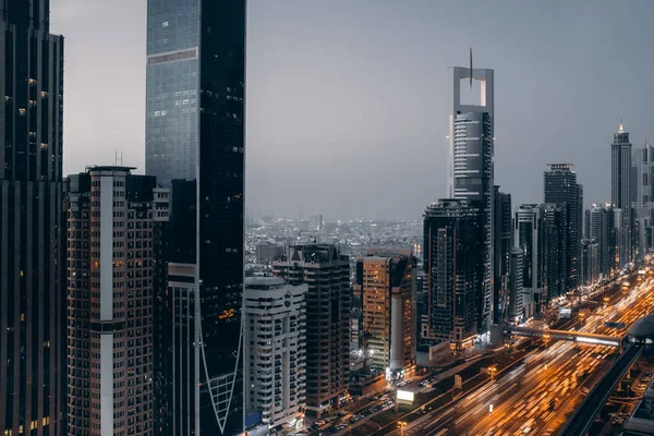 Beautiful aerial view to Dubai downtown city center lights skyline in the twilight, United Arab Emirates. Long exposure light trails effect — Stock Photo, Image