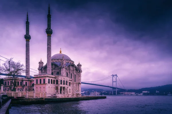 Ortakoy Mosque és Bosphorus Bridge Isztambulban, Törökországban. Drámai égbolt. A július 15-i mártírok hídja ködben — Stock Fotó