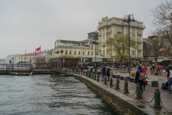 Helyi emberek sétálnak a tengerparton: Ortakoy district, Isztambul, Törökország. Drámai esős ég — Stock Fotó