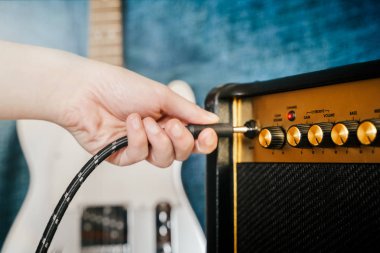 Gitar elektrik amplifikatör. Rock overdrive etkisi. El bir kabloyu amp prizine takmayı. Max ses ayarı. Sığ derinlik-in tarla