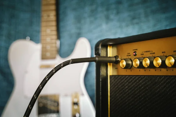 Amplificador eléctrico de guitarra. Efecto de sobremarcha de roca. Cable conectado al conector de amplificador. Botón de control de volumen máximo. Profundidad superficial del campo — Foto de Stock