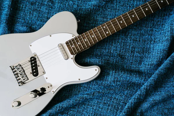 Fondo de rock eléctrico de guitarra. Vista superior sobre tela textil azul — Foto de Stock