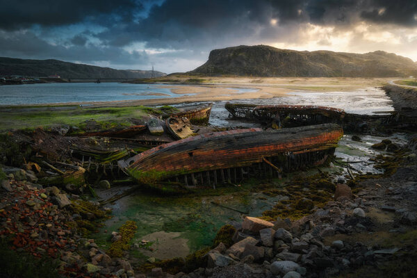 Заброшенное судно кладбище во время отлива возле села Териберка Мурманской области. Кольский полуостров, Северная Россия
