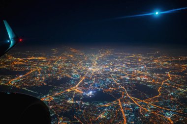 Uçaktan gece şehrine hava görüntüsü. Gökyüzündeki ay