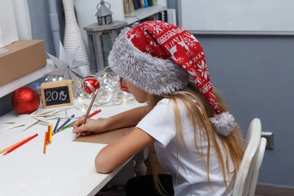 Uma Linda Garota Natal Chapéu Papai Noel Absorvida Por Escrever — Fotografia de Stock