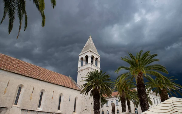Trogir, Hırvatistan-20 Haziran 2020: St. Peter 's kilise çan kulesi karanlık, fırtına bulutları tarafından gölgeleniyor, şiddetli yağmur ve dolu ile kötü hava koşullarını Adriyatik' in orta kıyısındaki bu Unesco dünya mirası kasabasına getiriyor.