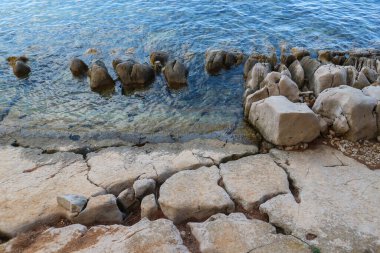 Vrgada adasında su kenarında ilginç kaya oluşumları olan güzel taş plajlar.