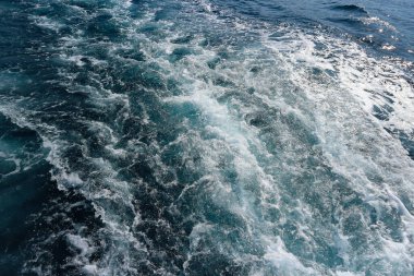 Sürat teknesi arkasında beyaz köpük ve iz bırakıyor.                           