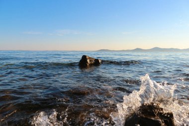 Gün batımından önce Pakostan kasabası yakınlarındaki Dalmaçya kıyısında kaya taşları üzerinde küçük uyanmalar.               