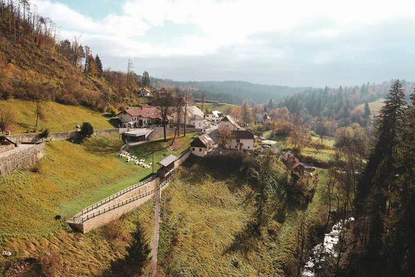 Predjama, Slovenya-11 Ekim 2018: Predjamski Grad kalesi, ünlü turistik merkezin önündeki güzel küçük köy