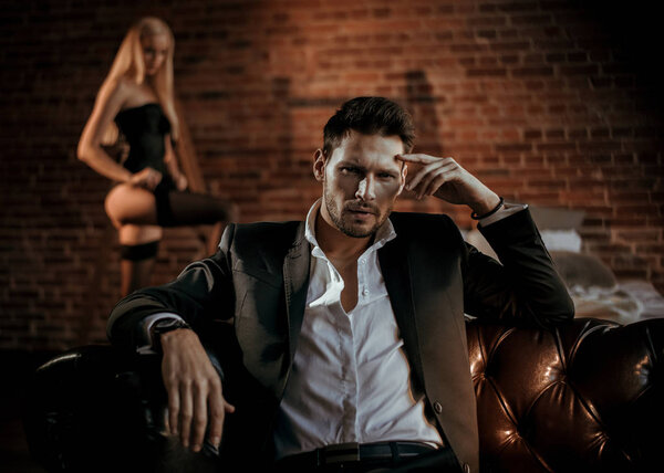 Портрет элегантного парня с блондинистым любовником на заднем плане
