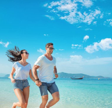 Genç, neşeli çift rahatlatıcı bir tropikal plaj