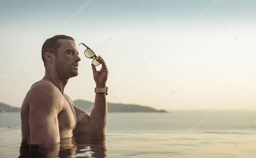 Portrait of a muscualar man relaxing in a tropical, hot water