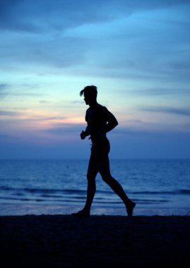 Kaslı adam bir tropik sahilde - egzersizleri akşam koşu