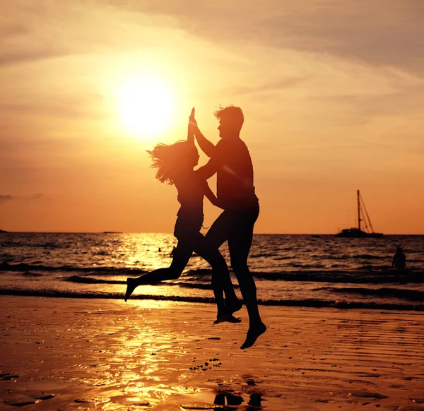 Egy fiatal pár, a trópusi tengerparton, pózol a suns portréja — Stock Fotó