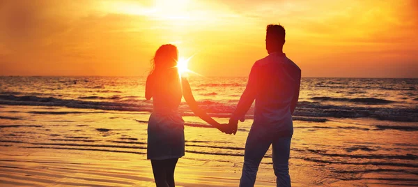 Junges Paar blickt auf den romantischen, tropischen Sonnenuntergang — Stockfoto