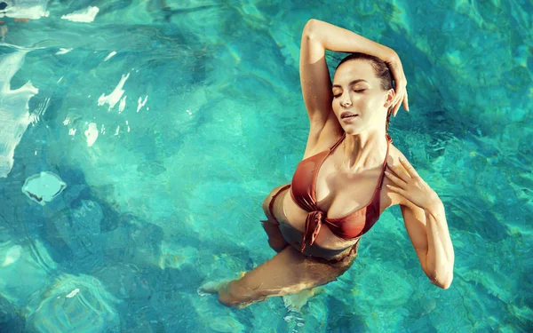Sinnliche Frau, die sich in einem heißen, tropischen Pool erholt — Stockfoto
