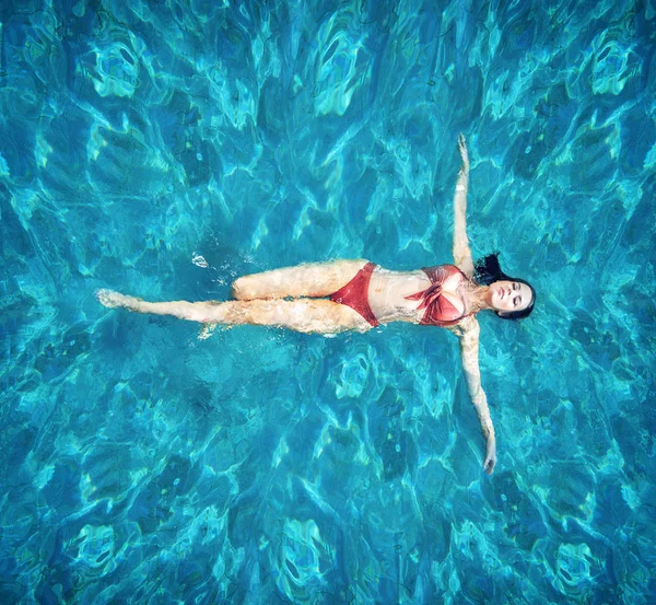 Şehvetli kadın realxing bir sıcak, tropikal havuzda