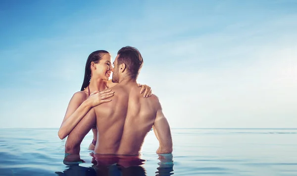 Retrato de una pareja joven y sensual relajándose en una piscina tropical —  Fotos de Stock