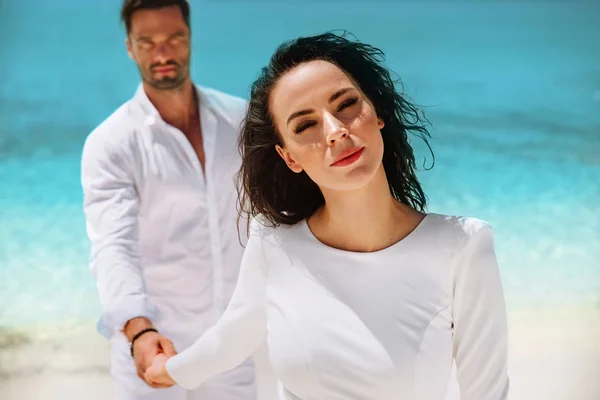 Sensual, elegante casal posando em uma praia tropical — Fotografia de Stock