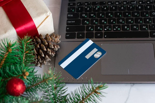 Noel tatili için kredi kartıyla online Noel alışverişi. Kara Cuma. Mavi kredi kartı. Not defteri, Noel süslemeleri, hediyeler, beyaz mermer arka plan.