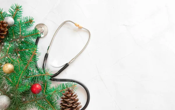 Noel 'i sağlık hizmetlerinde kutluyoruz. Düz manzaralı. Beyaz mermer arka planda steteskop. Hediye kutusu, kopyalama alanı ve afişi olan tıbbi Noel kartı