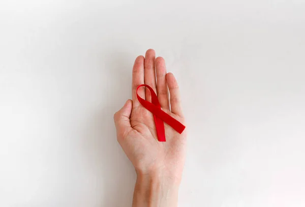 Mano Femenina Con Cinta Roja Sobre Fondo Blanco Concepto Concienciación —  Fotos de Stock