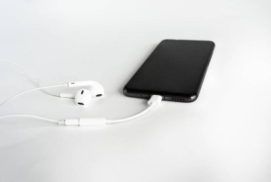 Akıllı telefon ve kulaklıkla USB 'den 3.5 mm' ye kadar olan kulaklık akıllı telefondaki C tipi kablo adaptörü. Beyaz arkaplanda.