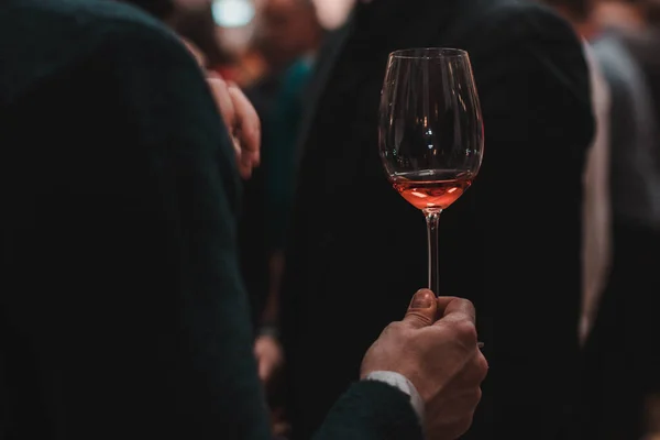 Elinde kırmızı şarap olan bir adam.