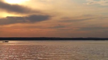 Gemilerin martı olduğu suların üzerinde gün batımı balık yakaladı.