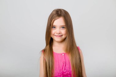 Beyaz arka planda pembe elbiseli küçük bir kızın portresi. Metnin için kopyalama alanı olan çocuk duyguları kavramı