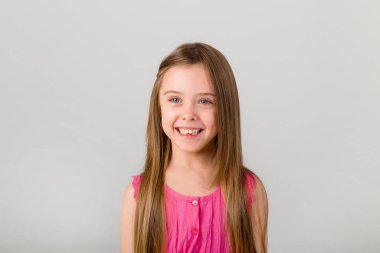 Beyaz arka planda pembe elbiseli küçük bir kızın portresi. Metnin için kopyalama alanı olan çocuk duyguları kavramı