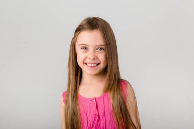 Beyaz arka planda pembe elbiseli küçük bir kızın portresi. Metnin için kopyalama alanı olan çocuk duyguları kavramı