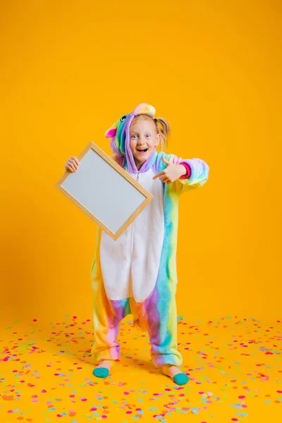 Une Heureuse Petite Fille Dans Une Licorne Kigurumi Unitard Tient — Photo