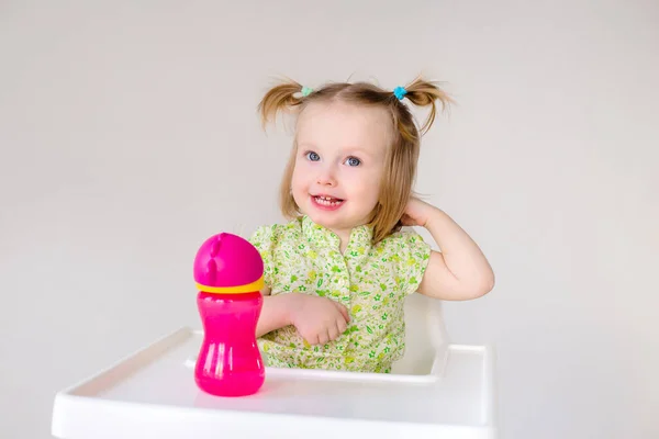 Dulce Niña Sienta Una Silla Alta Con Botella Agua Rosa —  Fotos de Stock