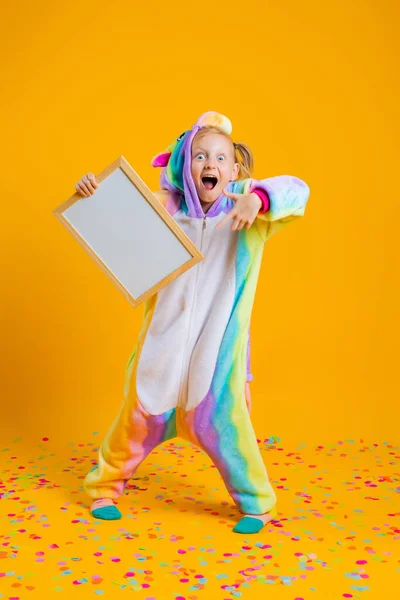 Une Heureuse Petite Fille Dans Une Licorne Kigurumi Unitard Tient — Photo