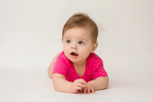 白い背景にピンクのボディスーツを着た健康な赤ん坊の女の子の写真 テキストや広告の配置でスペース画像をコピーします — ストック写真