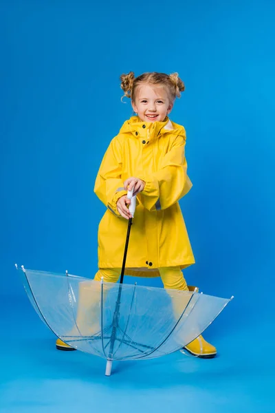 Menina Alegre Uma Capa Chuva Botas Borracha Sobre Fundo Azul — Fotografia de Stock