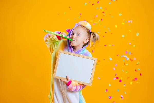 Szczęśliwa Dziewczynka Jednorożcu Kigurumi Unitard Trzyma Pustą Tablicę Tekst Żółtym — Zdjęcie stockowe