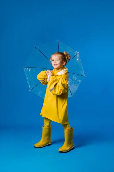 Menina Alegre Uma Capa Chuva Botas Borracha Sobre Fundo Azul — Fotografia de Stock