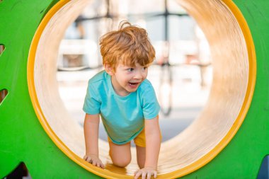 İki yıllık kızıl saçlı çocuk çocuk çocuk parkında kaliteli zaman geçiriyor..