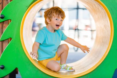 İki yıllık kızıl saçlı çocuk çocuk çocuk parkında kaliteli zaman geçiriyor..