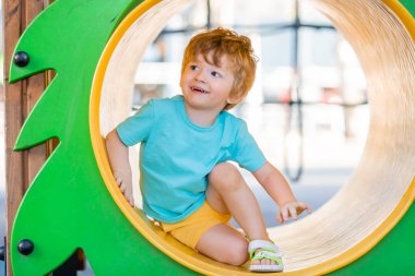 İki yıllık kızıl saçlı çocuk çocuk çocuk parkında kaliteli zaman geçiriyor..