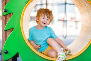 İki yıllık kızıl saçlı çocuk çocuk çocuk parkında kaliteli zaman geçiriyor..