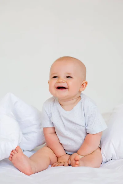 Foto Glad Liten Pojke Månader Vit Body Suit Sängen — Stockfoto