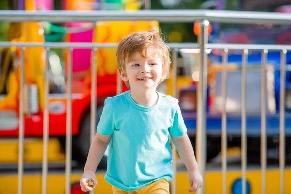 Mavi tişörtlü küçük mutlu çocuk yaz eğlence parkında yürüyüş yapıyor. Çocuk yaşam tarzı konsepti