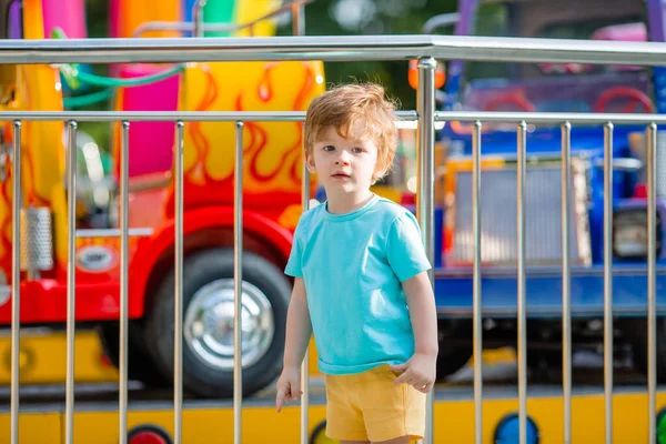 Mavi tişörtlü küçük mutlu çocuk yaz eğlence parkında yürüyüş yapıyor. Çocuk yaşam tarzı konsepti