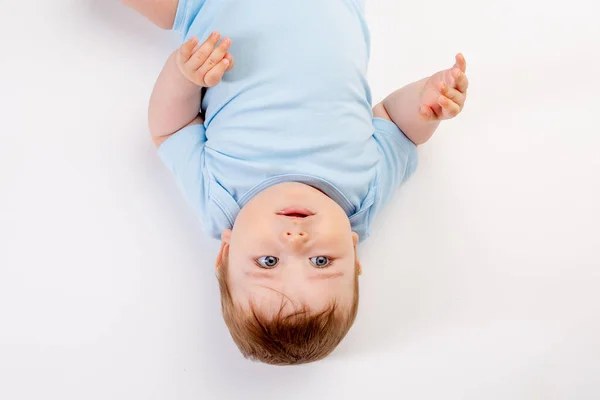 サイドダウン写真の下でかわいいです幼児男の子で青いボディスーツ上の白い背景とともにコピースペースのためにテキスト — ストック写真
