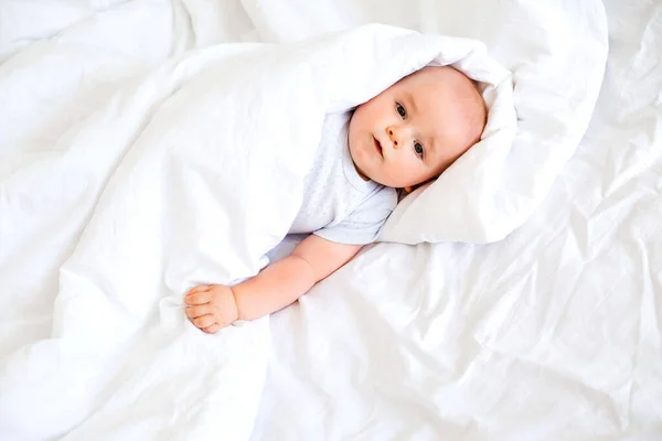 Cute Baby Boy Lay Bed Covered White Blanket Smiles Happily — Stock Photo, Image