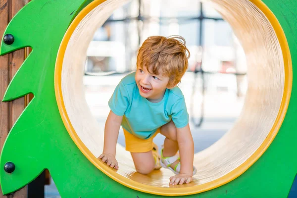 İki yıllık kızıl saçlı çocuk çocuk çocuk parkında kaliteli zaman geçiriyor..